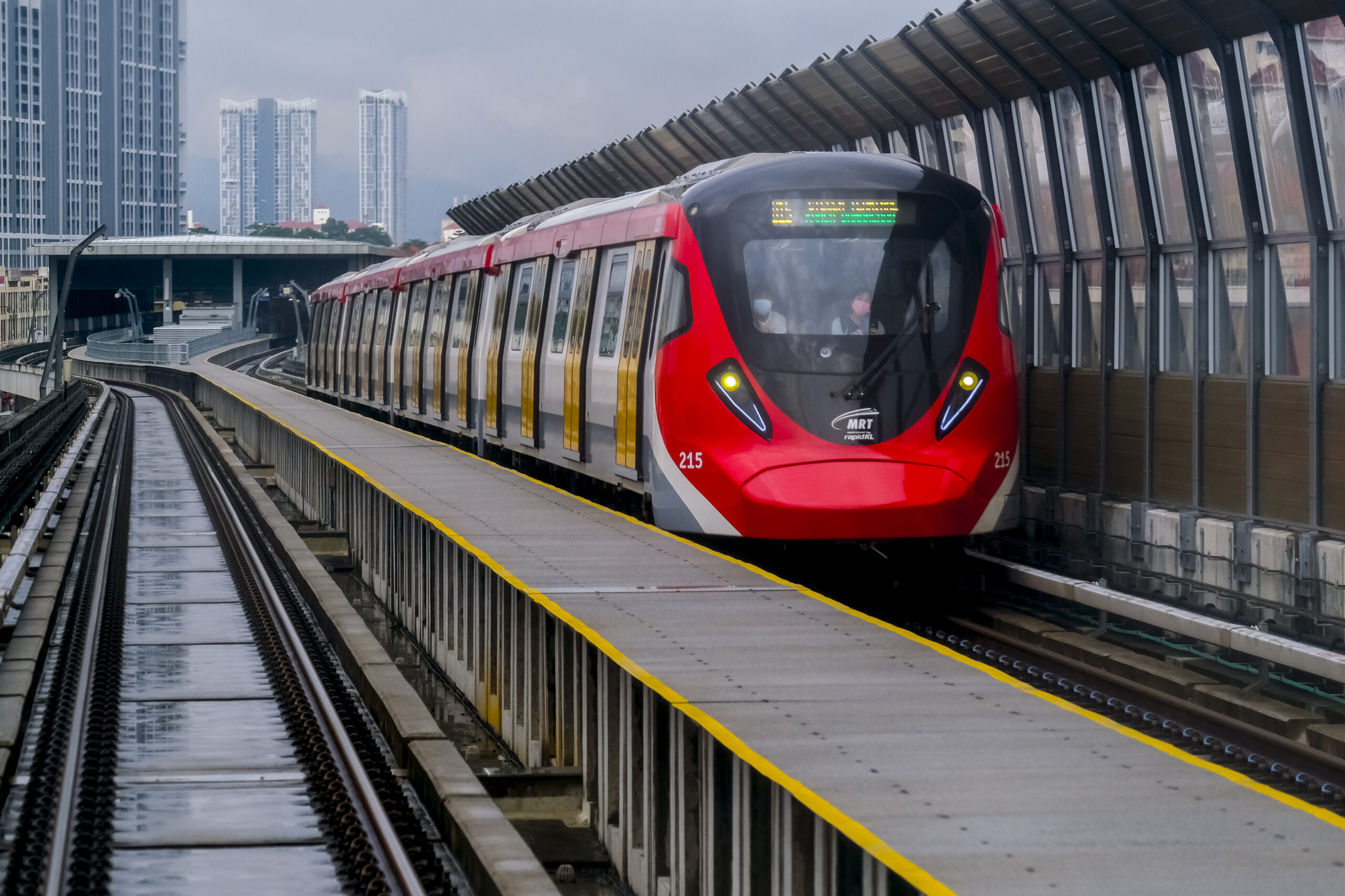 Modern Malaysian urban rail train arriving at an elevated station